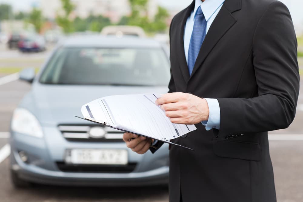 Man holding car documents, representing transportation and ownership concept