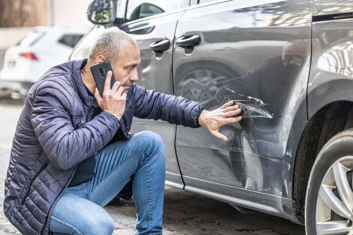 man touching car after car crash