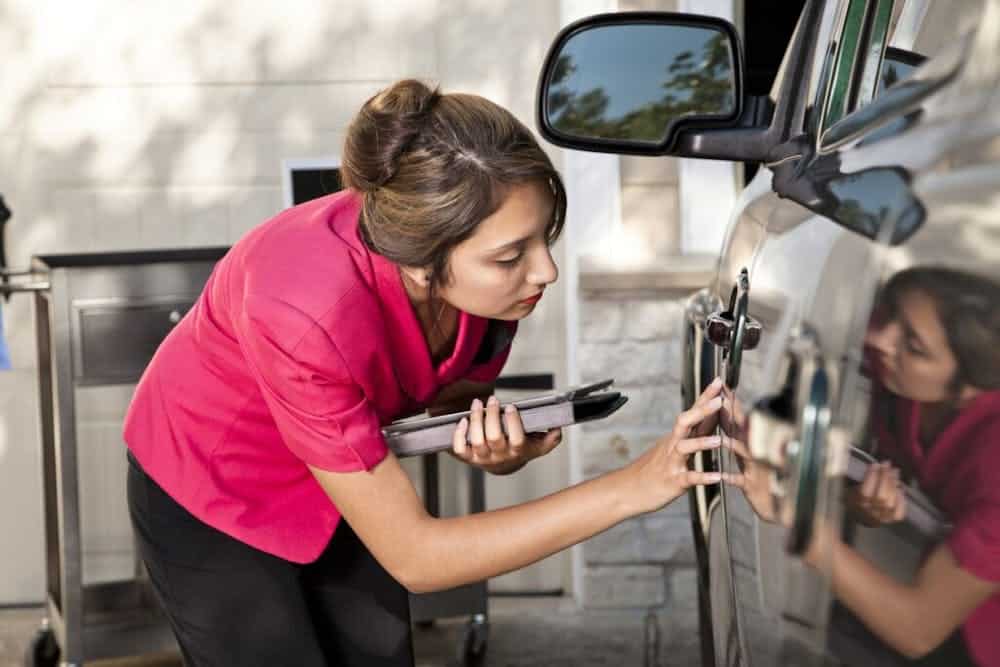 woman touching scratch on car