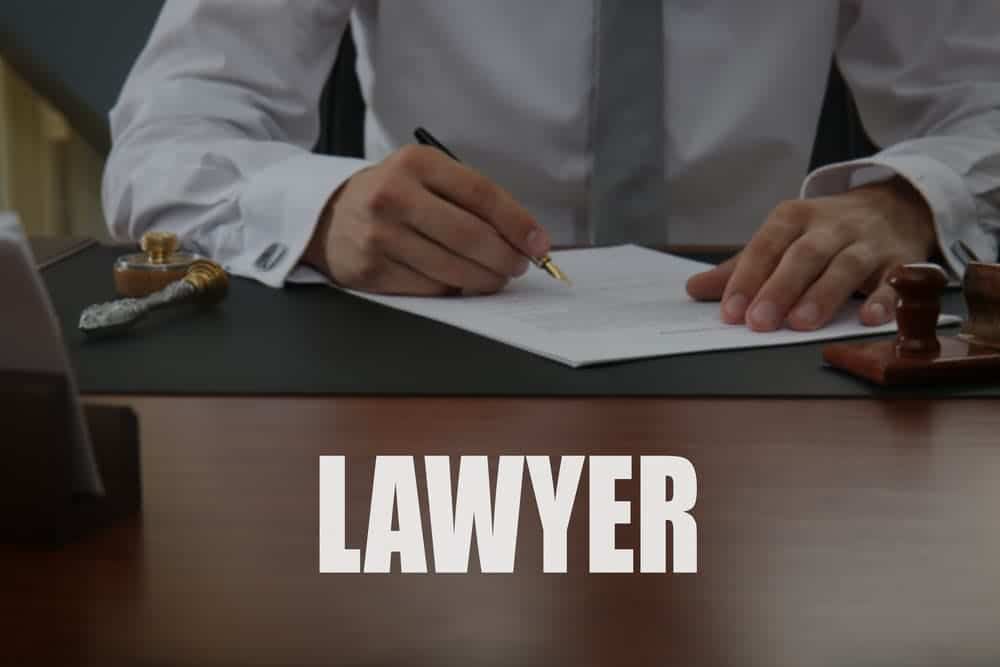 A notary public signing legal documents in an office setting.