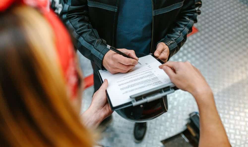 Man signing something on a clipboard