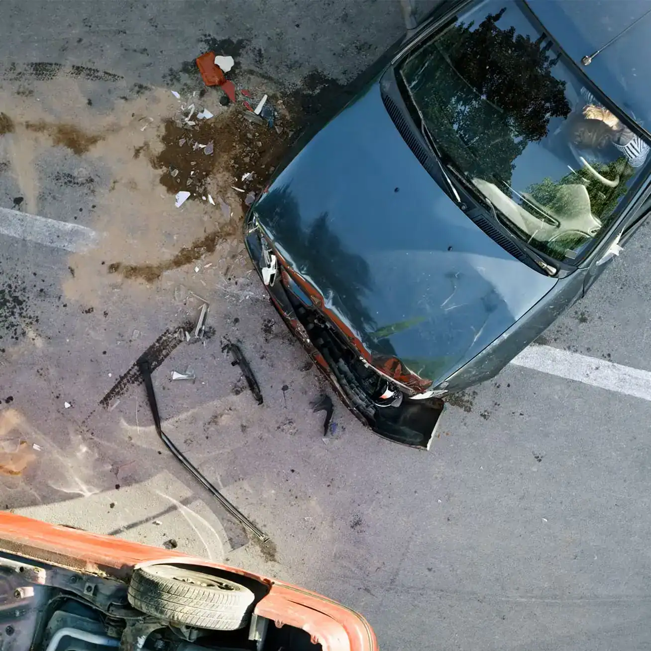 Overturned car and damaged vehicle after serious car accident with debris on the road
