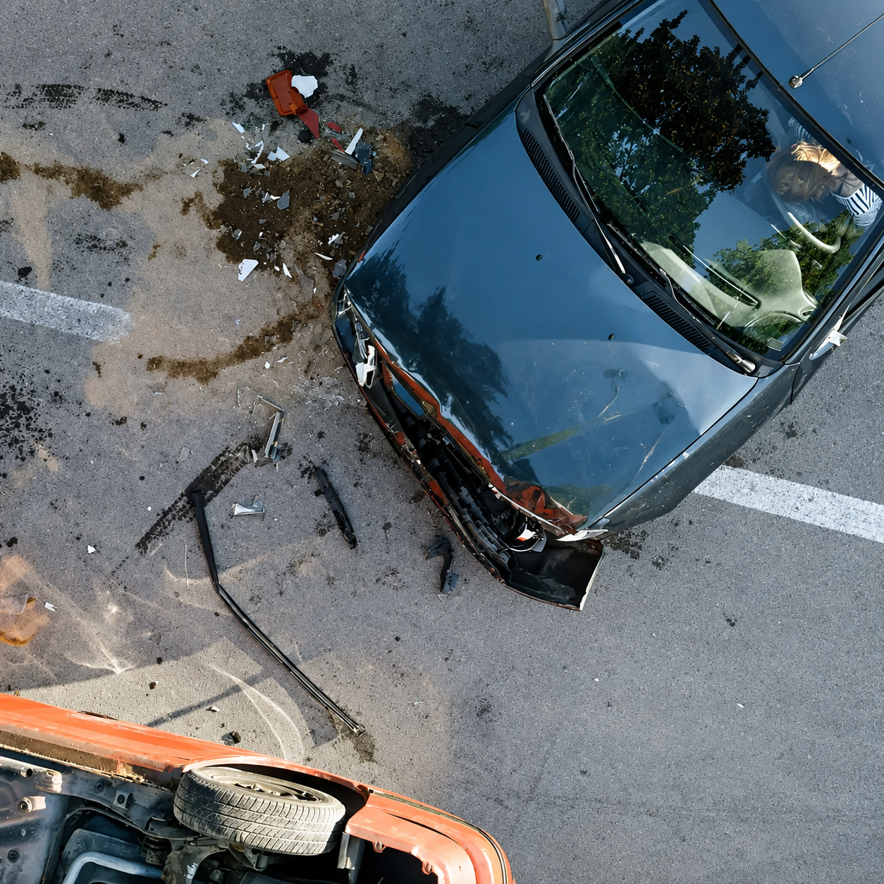Overturned car and damaged vehicle after serious car accident with debris on the road