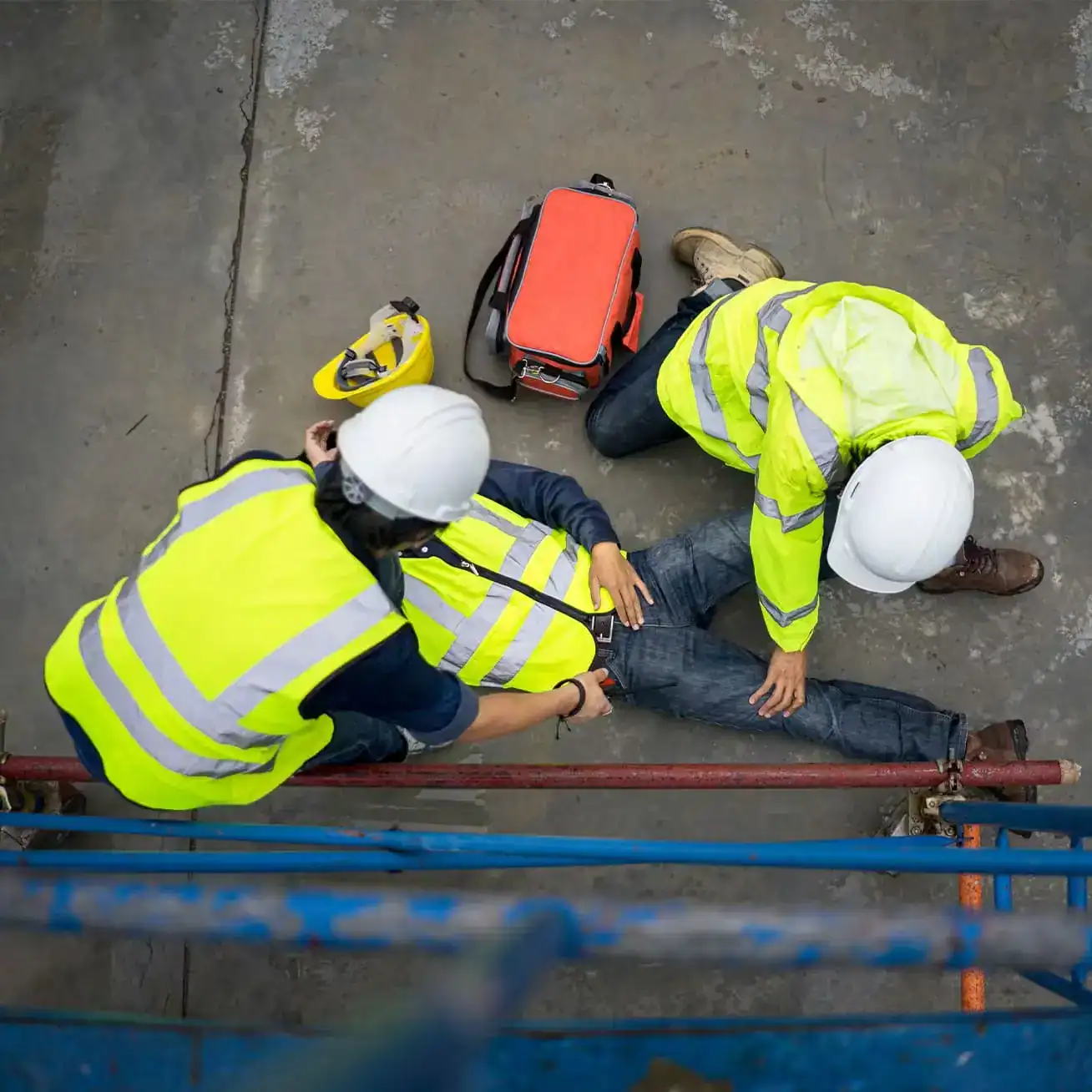 Construction worker injured in fall accident receiving help from coworkers at job site in Houston