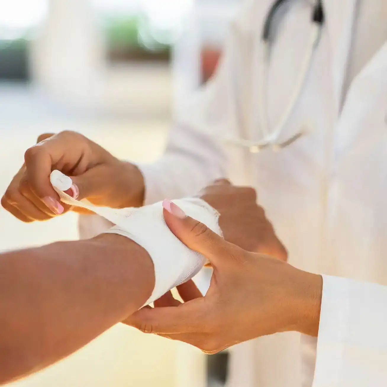 Doctor bandaging a patient’s arm injury after an accident, illustrating medical care and personal injury claims support.