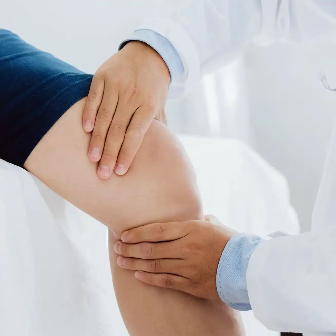 Doctor examining patient’s knee injury during medical checkup