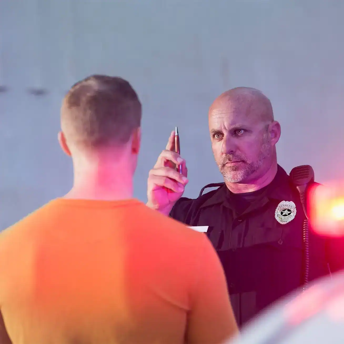 Police officer conducting field sobriety test on suspected drunk driver during DUI stop.