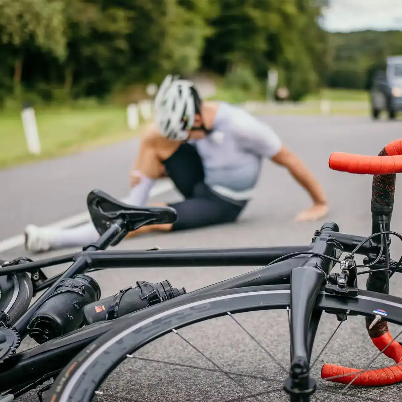 Injured cyclist sitting on road after bicycle accident in Houston, representing bicycle accident injury claims