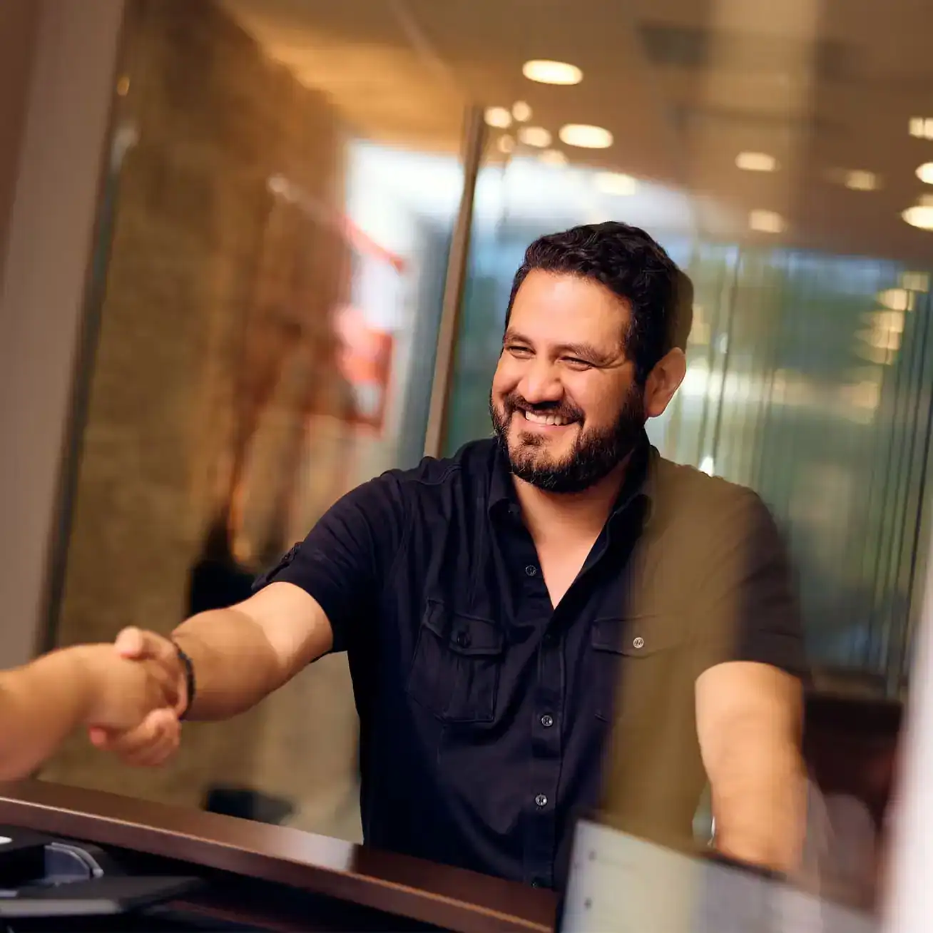 Happy client shaking hands with Houston personal injury lawyer at Stewart J Guss law office