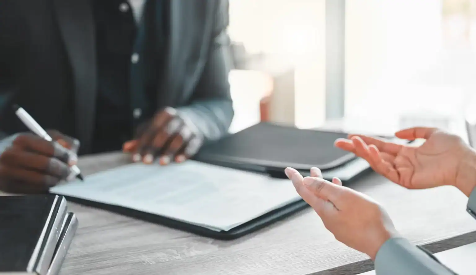 Close-up of lawyer and client discussing legal documents during injury case consultation
