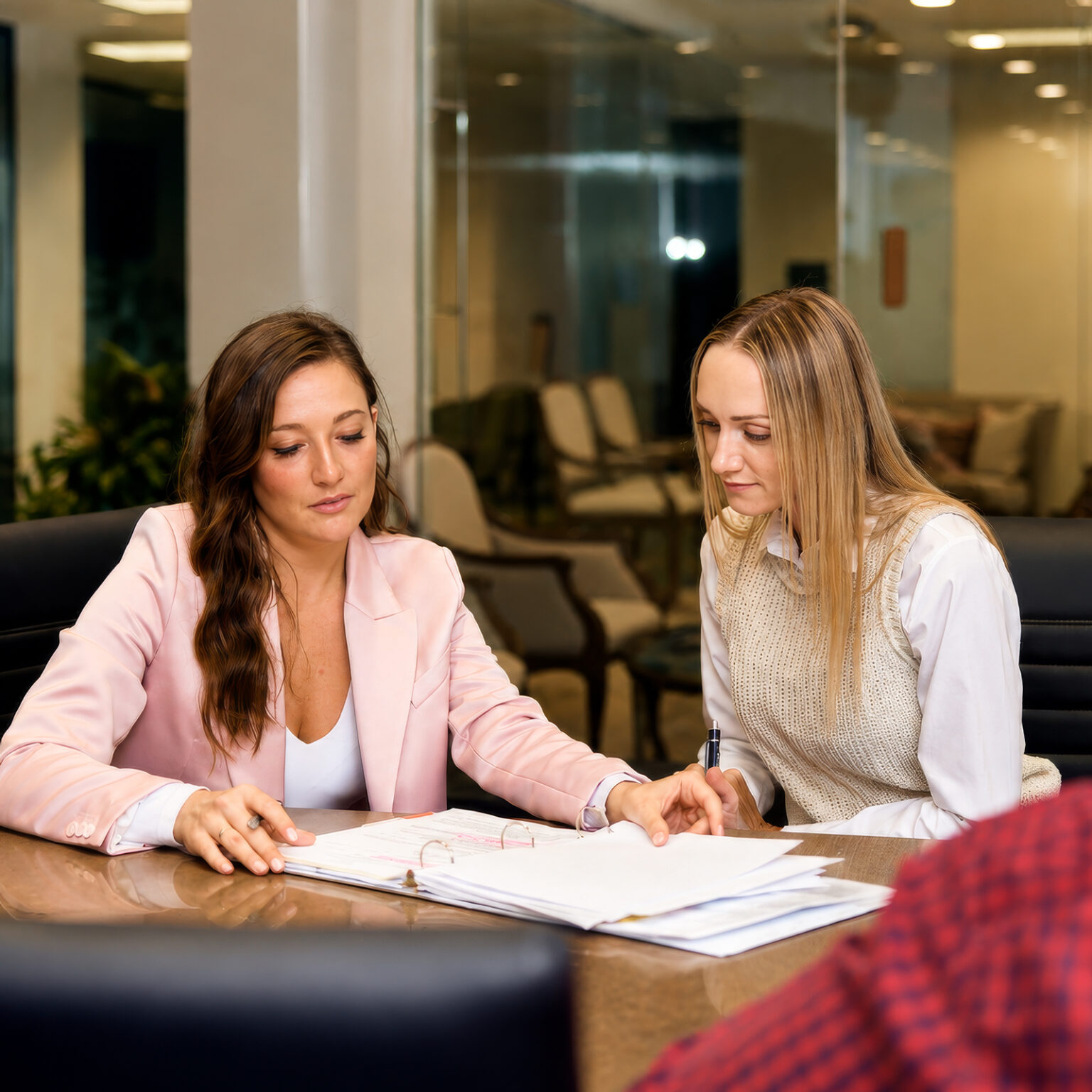 Two women reviewing legal documents during a personal injury consultation at Stewart J Guss law office
