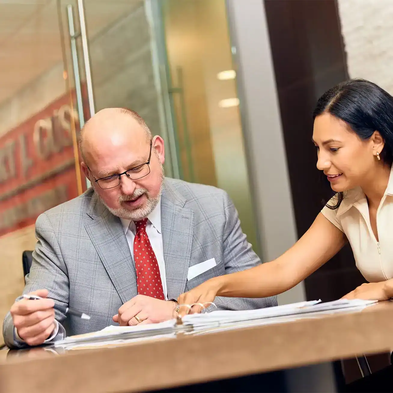 Attorney and client reviewing legal documents at Trust Guss Injury Lawyers office
