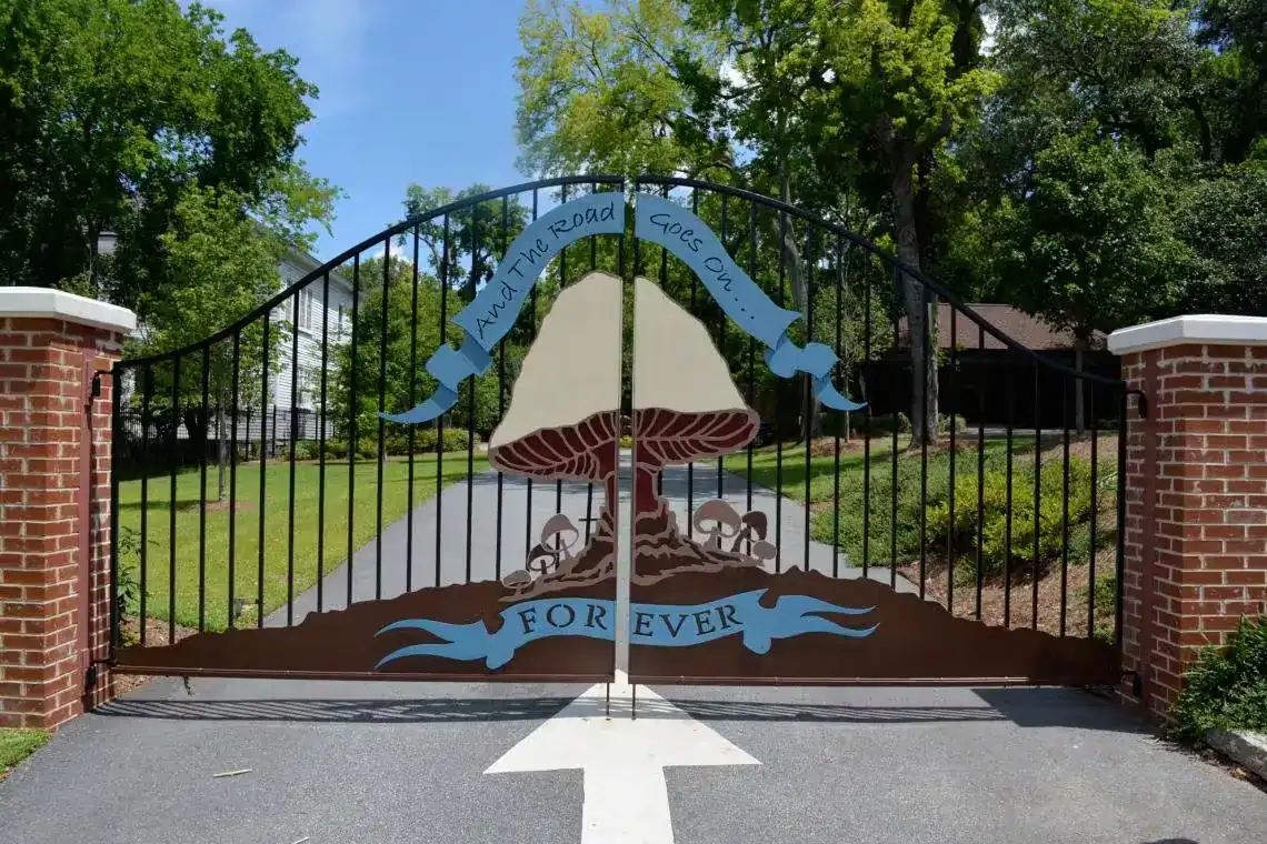 Decorative gate at The Allman Brothers Band Museum at The Big House in Macon, Georgia with mushroom artwork and the phrase And the Road Goes On Forever.