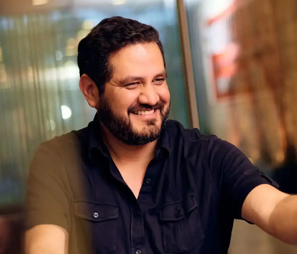 Smiling man in a professional setting during a consultation, representing trusted client relationships at Stewart J. Guss Injury Accident Lawyers.