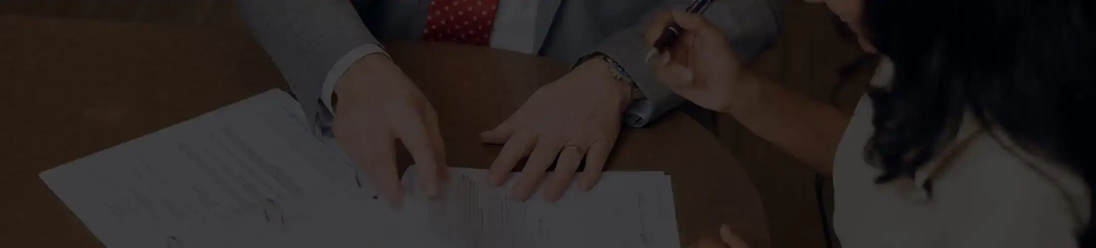 Personal injury attorney reviewing and signing legal documents with client during case consultation