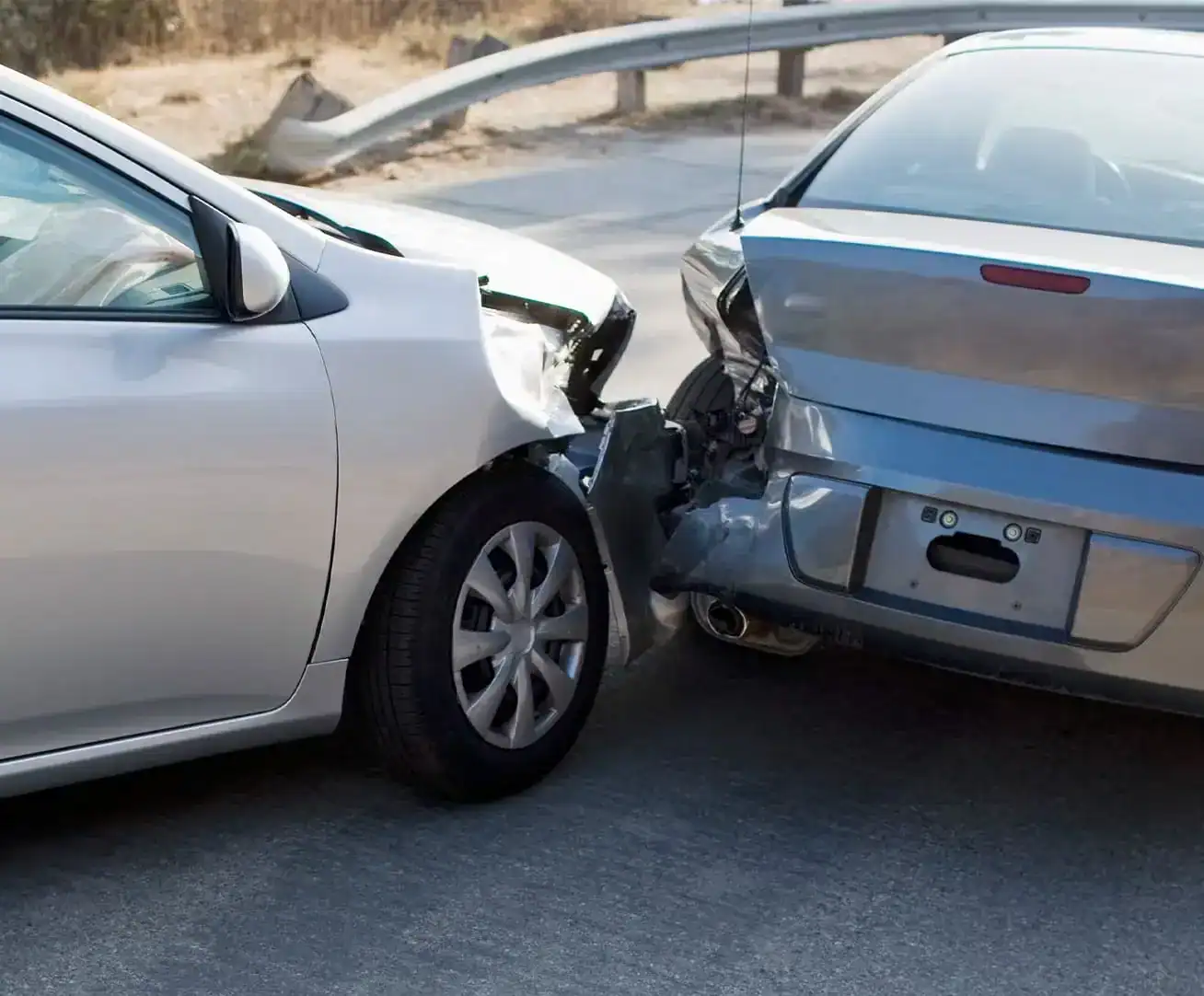 Two cars involved in a rear-end collision showing front-end and back-end damage on the roadway.