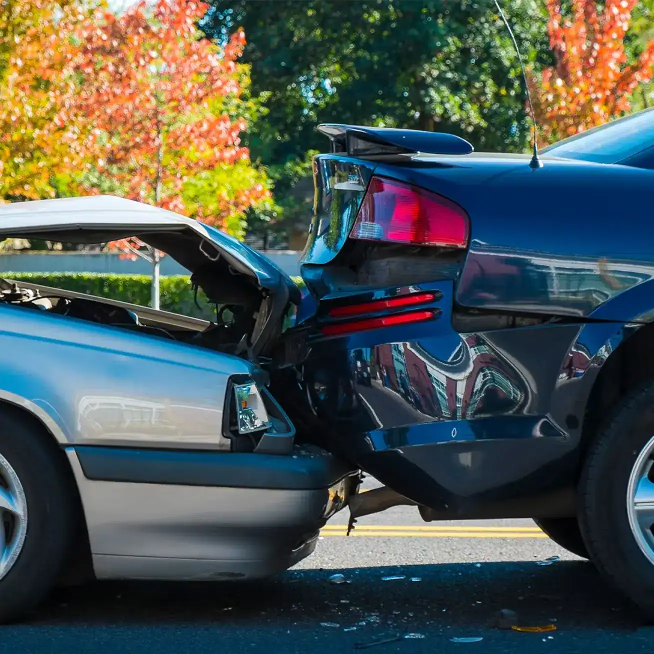 Two cars in rear-end collision showing severe front and back damage