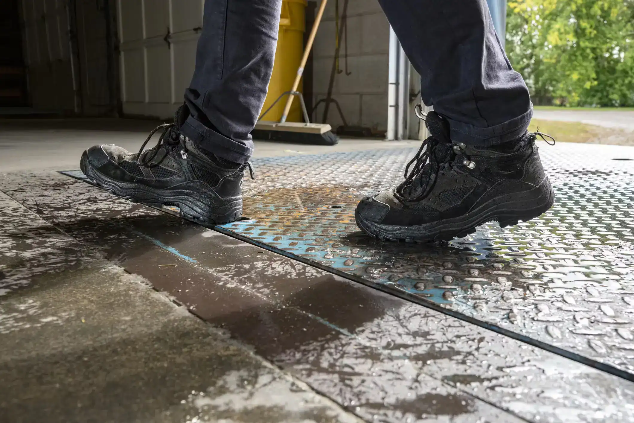 Worker wearing boots slips on wet floor surface in workplace environment