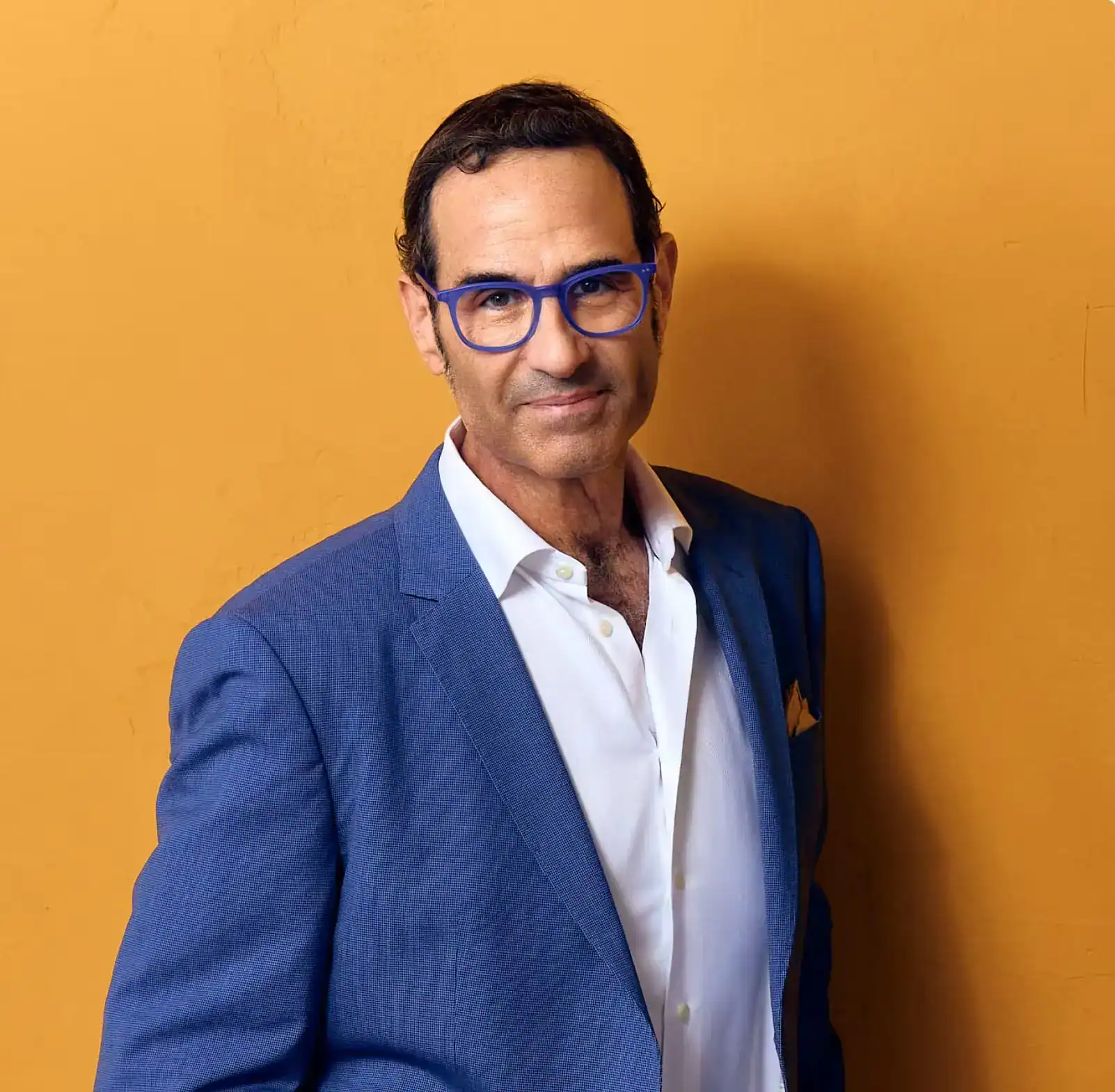 Stewart J. Guss Houston personal injury lawyer professional portrait in blue suit with orange background