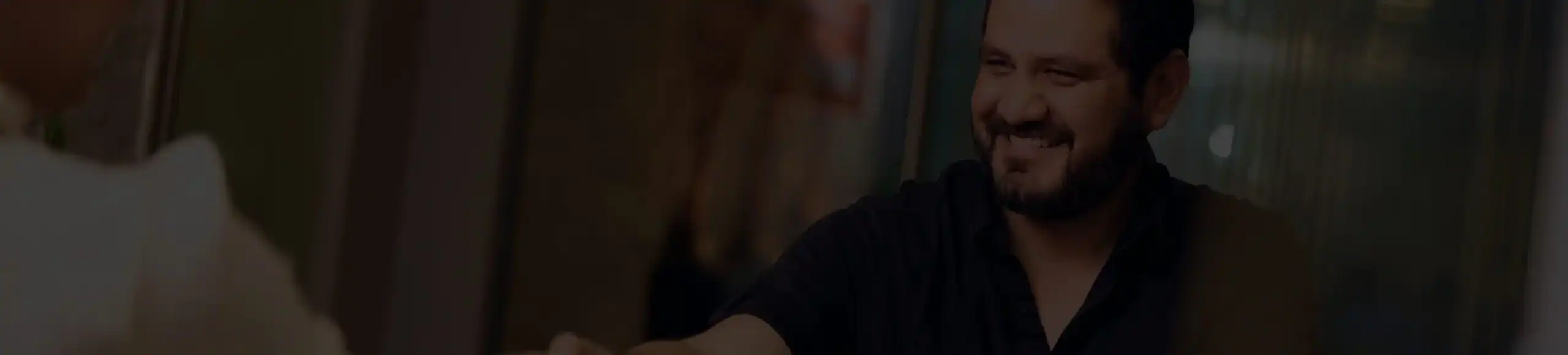 Client smiling while shaking hands during consultation at Stewart J. Guss Injury Lawyers office