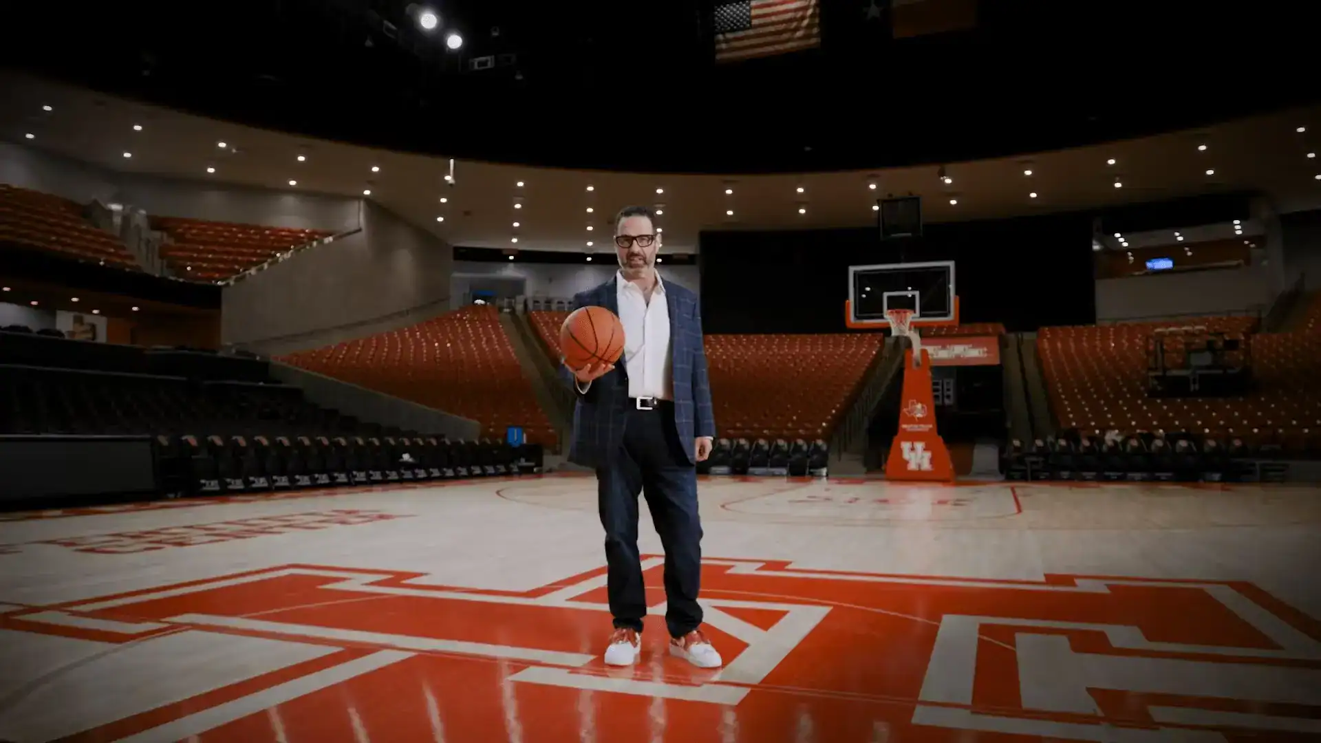 Stewart J. Guss, Houston personal injury attorney, holding a basketball on the University of Houston court