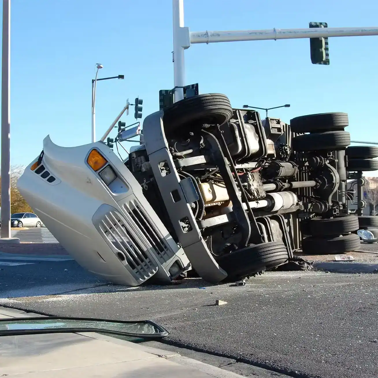 Overturned semi-truck lying on its side after a serious accident at a city intersection.
