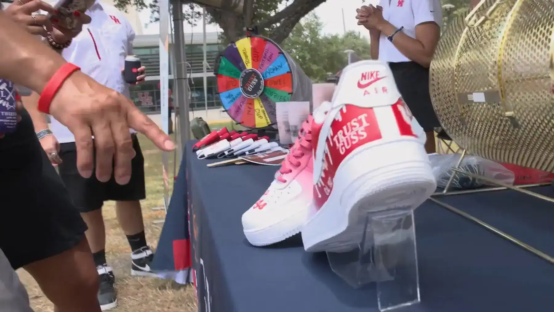 Custom Nike Air shoes with Trust Guss branding displayed at Houston community event booth