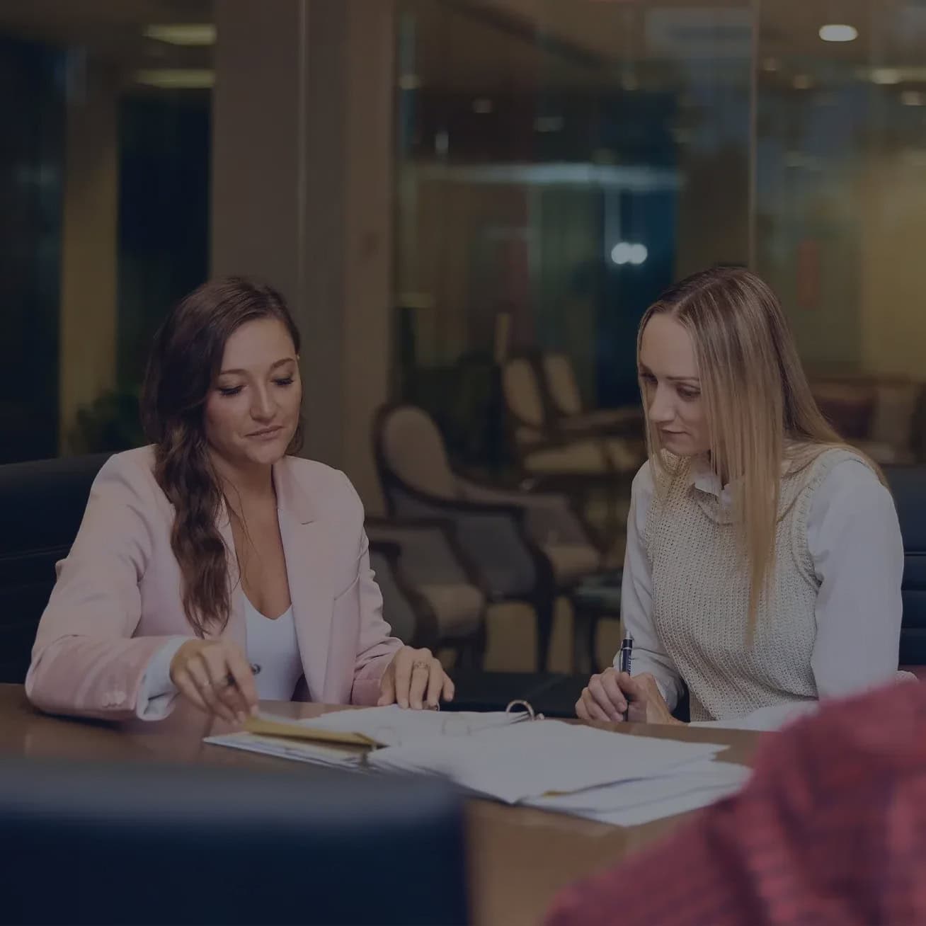 Two women reviewing legal documents during a personal injury consultation at Stewart J Guss law office