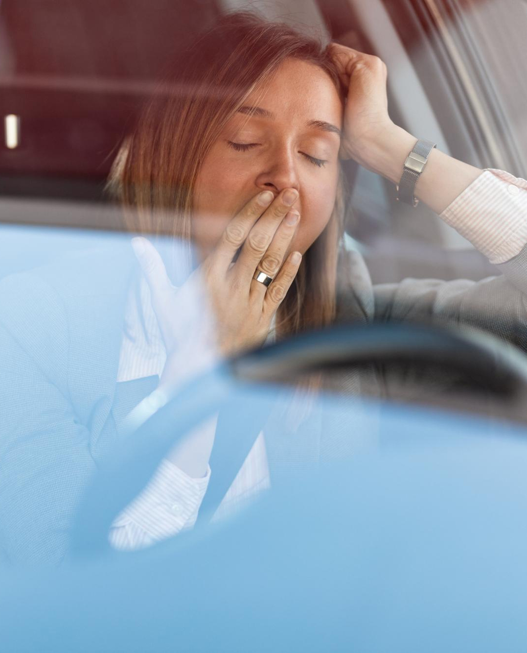 Businesswoman Feeling Tired And Yawning While Driving A Car The View Is Through The Glass